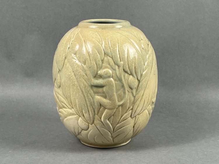 Georges CHEVALIER (1894-1987, dessinateur) et MOUGIN Frères (éditeurs), Nancy Lorraine, pour La MAITRISE (Ateliers des arts appliqués des Galeries Lafayette). Beau vase Art Déco en grès émaillé beige, à décor de singes dans des feuilles de bananiers. Années 1920-1930. Signé sous la base et numéroté 4 M. Diam. 20 cm - haut. 23 cm. Pas d’accident constaté. Provenance : collection Geneviève Aubry (1948-2025), Rosières-aux-Salines.