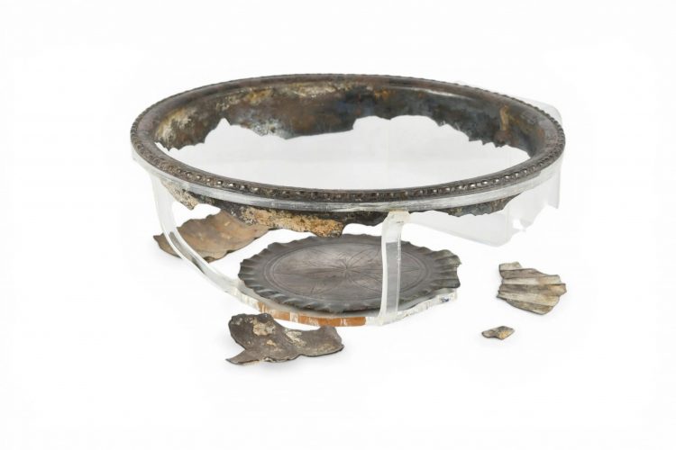 Plateau ovale en argent, légèrement concave, sur pied ovale bas. Sur le rebord, une moulure de perles et de pirouettes. Il n'y a pas d'autre décor qu'un sillon étroit mais net, à l'intérieur, correspondant au tracé du pied. Au revers, un graffite presque effacé : AVC. Milieu du IIIème s. apr. J.-C. L. 19,4 cm. 